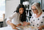 Two women look at a magazine