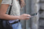 woman in striped shirt looks down at her phone