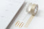 Two rolls of washi tape, rolled out and stuck to a desk next to a calendar and two gold paperclips.