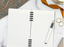 A notebook and a fountain pen on a white tabletop