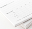 A stack of progress tracking notepads