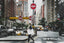 a busy new york city street scene with a women crossing the stress with a big bag