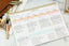 an ink+volt dashboard deskpad filled out with tasks with a gold fountain pen