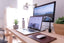 A laptop and desktop computer on a clean wooden desk